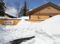 雪に埋もれる森の旅亭びえいの玄関