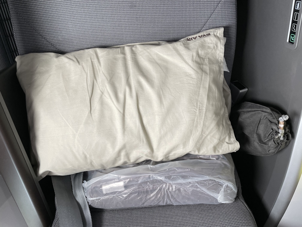 シートに用意された枕とスリッパ、掛け布団