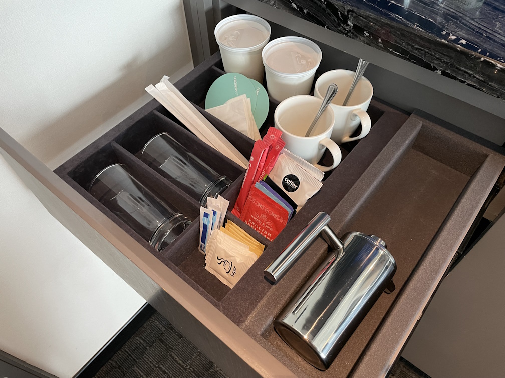 テーブル下の引き出しには、グラスやマグカップ、ティーバッグ、ミルク、シュガー、コースターなどのフリードリンク類の一式が収納されている