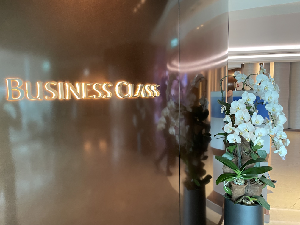 ビジネスクラスラウンジの入口ロゴと美しい胡蝶蘭