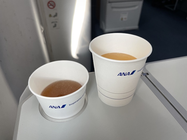 ドリンクサービスでいただいたアップルジュースとコンソメスープ